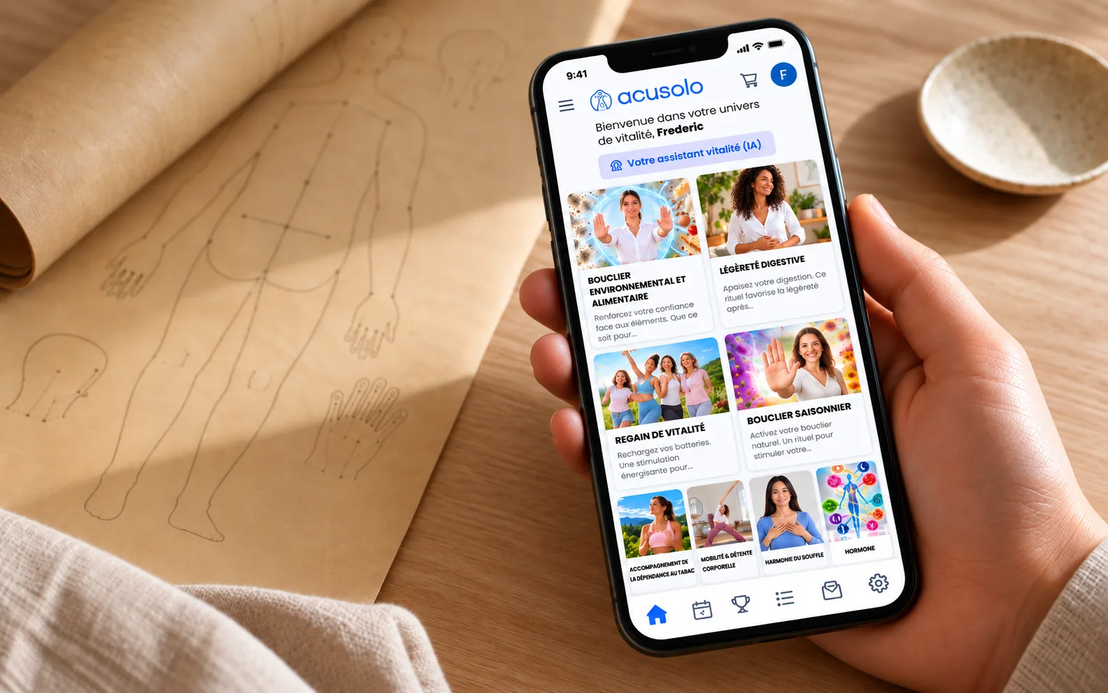 Une main tient un téléphone ouvert sur l'application Acusolo, près d'une planche de méridiens ancienne